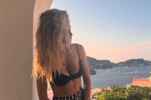 Elena Santarelli seduta su un balcone con dà su un panorama mozzafiato