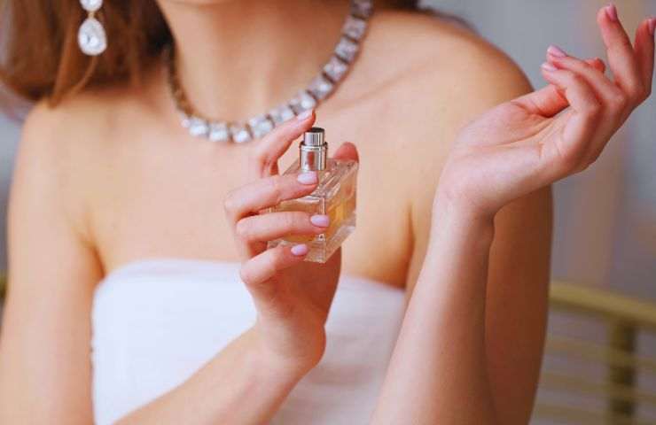 ragazza si spruzza il profumo