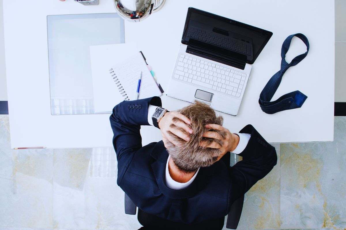 Impiegato disperato con le mani tra i capelli