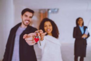 Coppia sorridente tiene in mano le chiavi della nuova casa