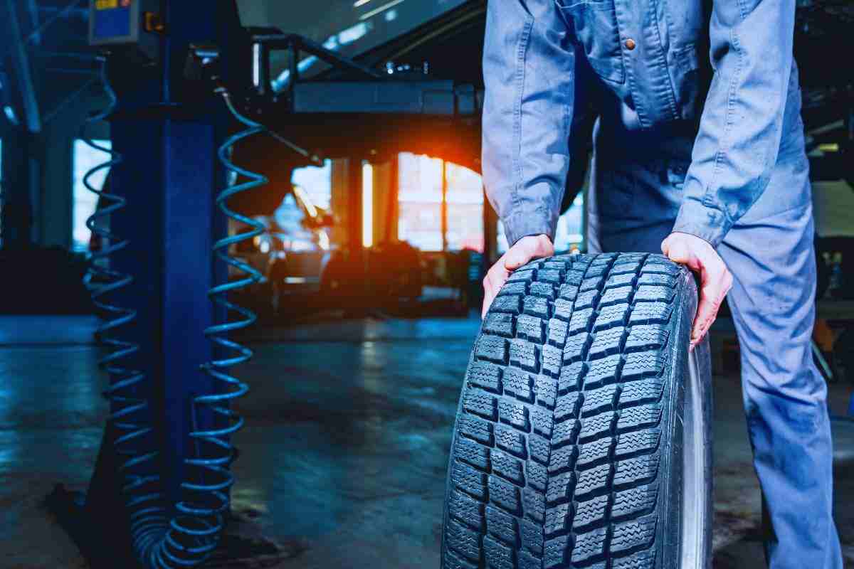 Gommista che trasporta un pneumatico invernale