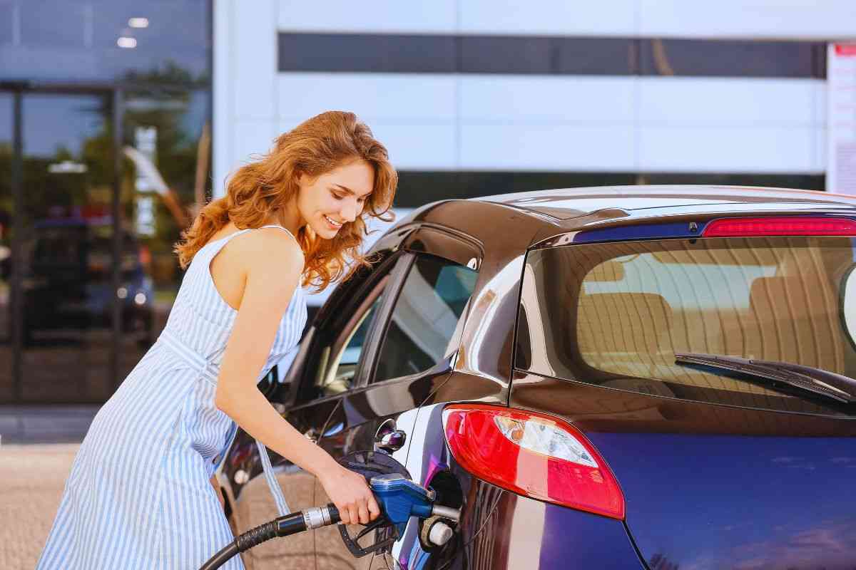 Donna che effettua rifornimento di benzina alla sua auto