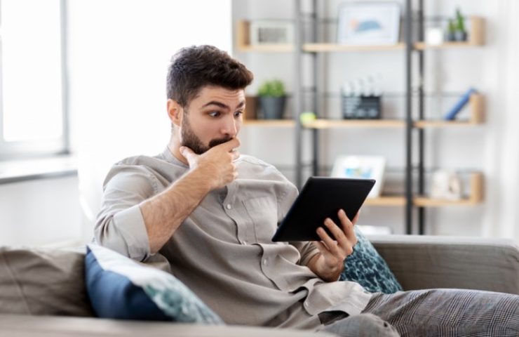 uomo sconvolto guarda il tablet