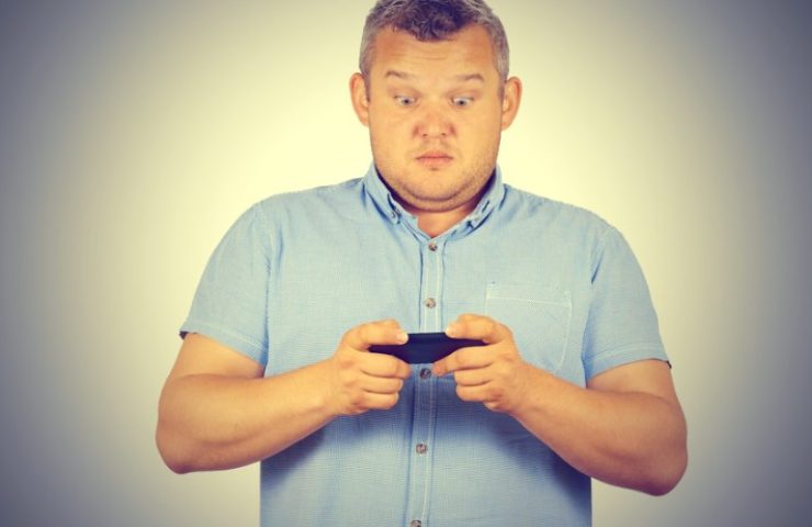 Uomo al telefono con la faccia sconvolta