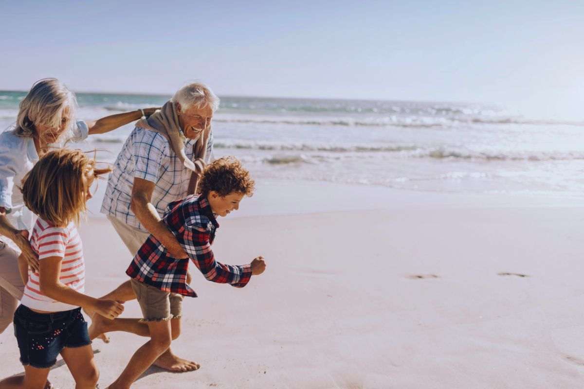 Nonni che giocano i nipoti in spiaggia