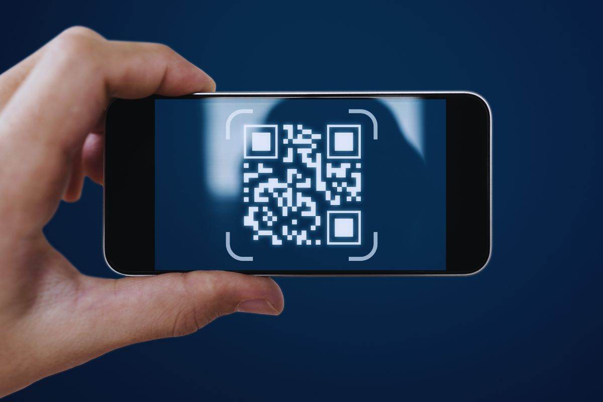 Persona che inquadra codice qr con smartphone