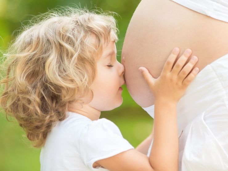 bambino che bacia pancione mamma