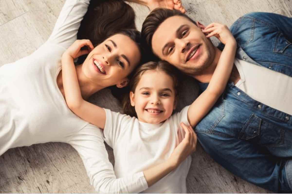 mamma papà e bambina sdraiati insieme