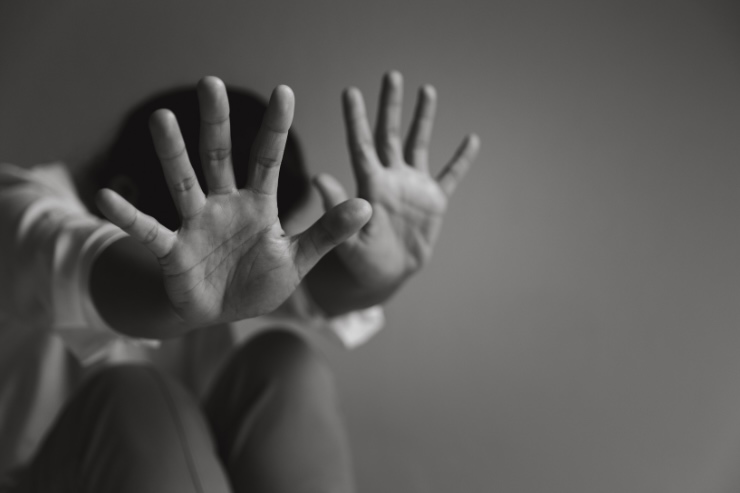 donna con le mani alzate per difendersi