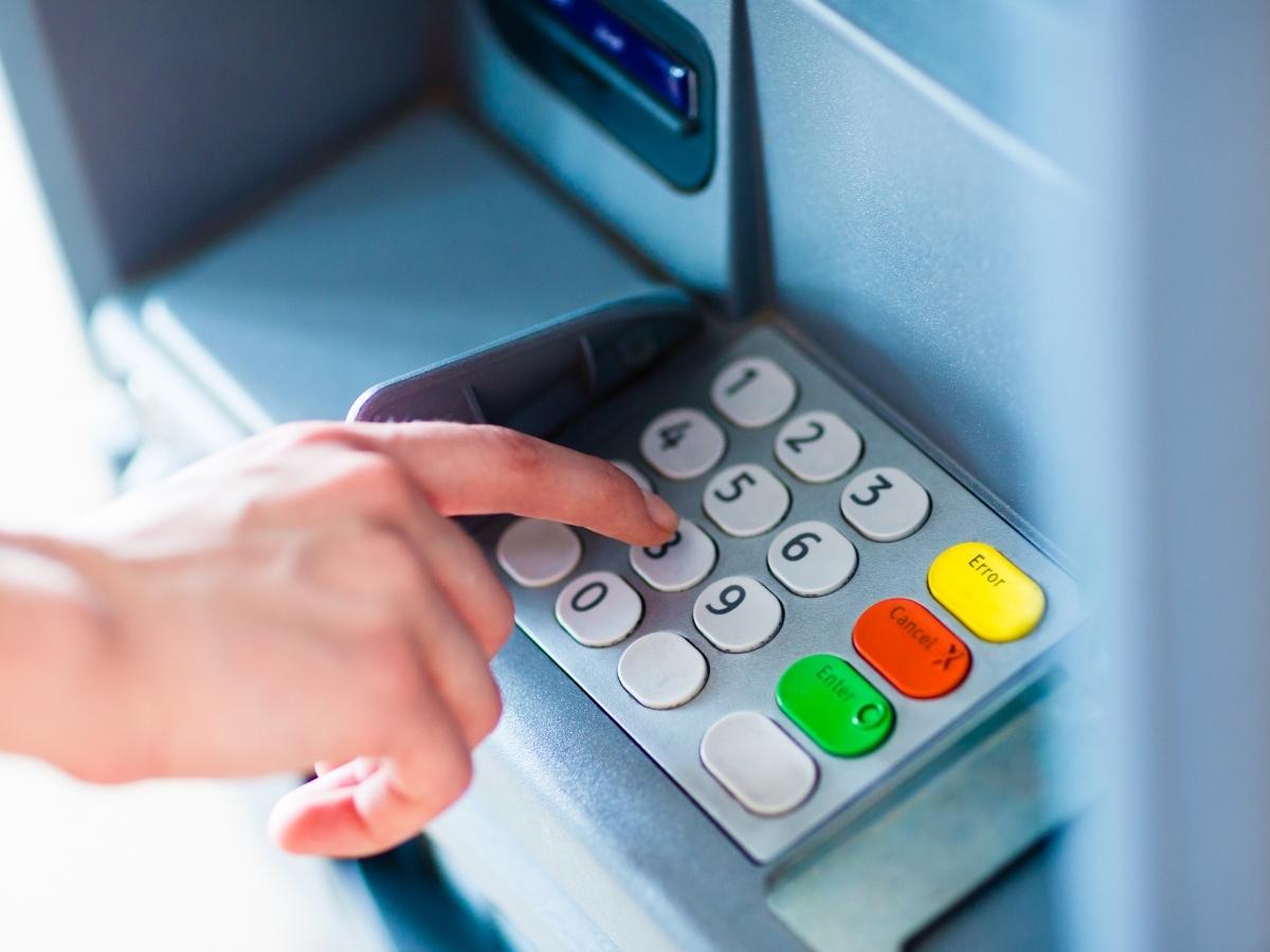 uomo preleva soldi atm