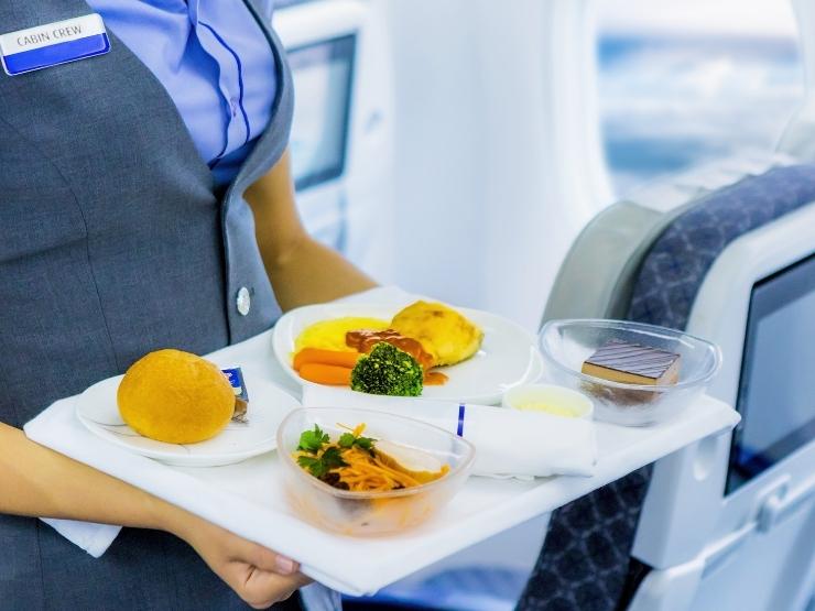 assistente di volo che porta cibo e bevande
