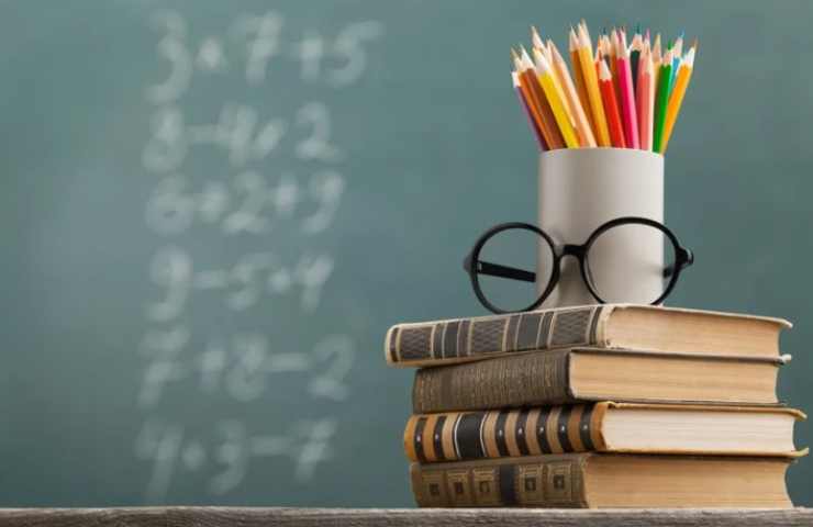 matite e libri con lavagna sullo sfondo