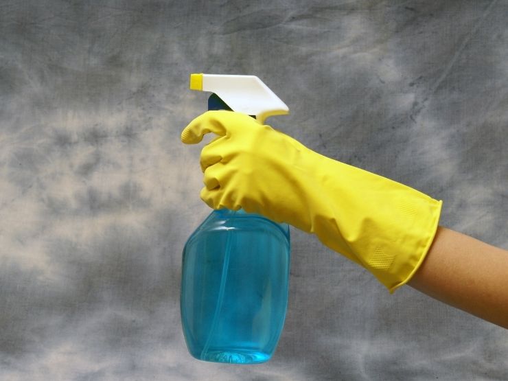 donna con in mano un flacone spray 