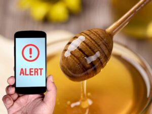 scritta allerta su telefono e miele