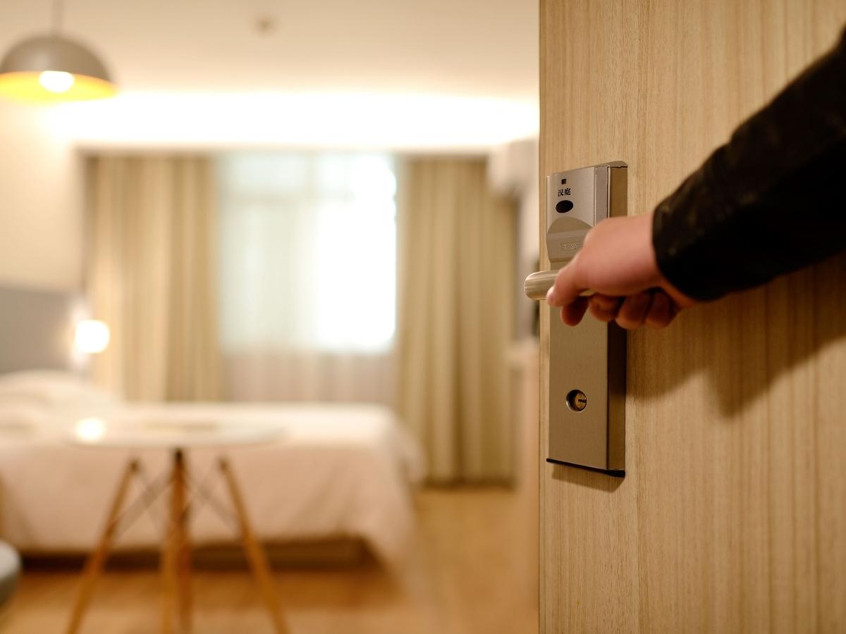 uomo che apre stanza hotel