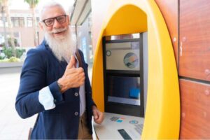Uomo anziano felice al bancomat