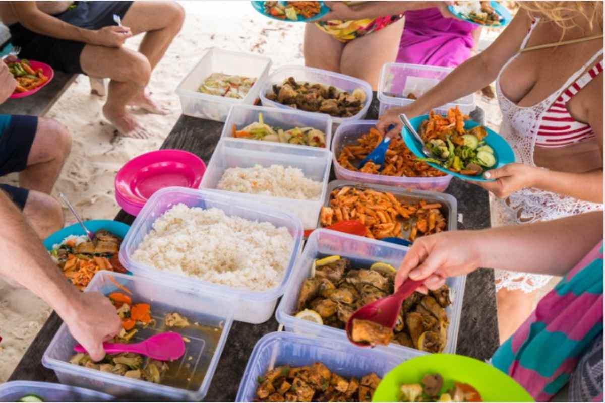 Contenitori di plastica pieni di cibo in spiaggia