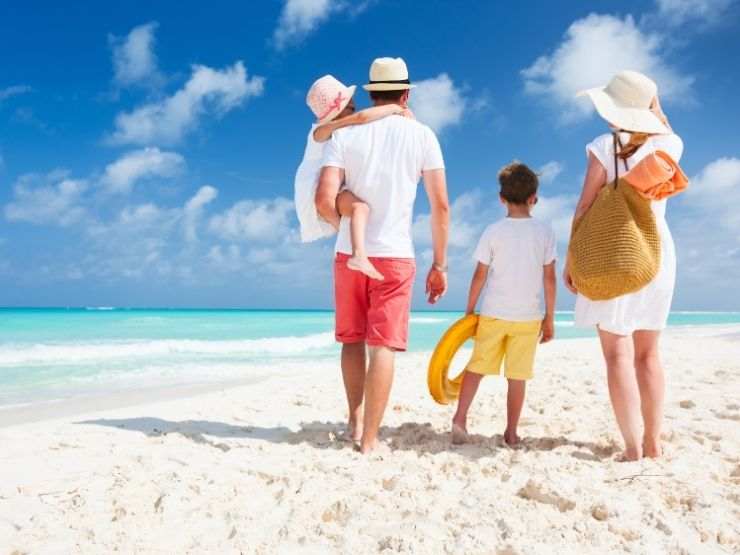 famiglia che cammina in riva al mare