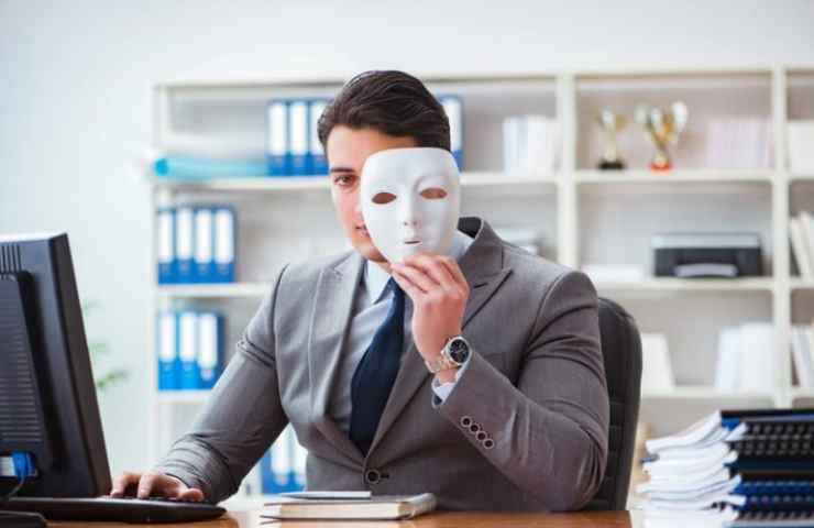 Uomo al pc con una maschera