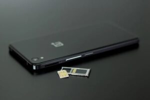 Cellulare con lo slot della sim smontato e una sim
