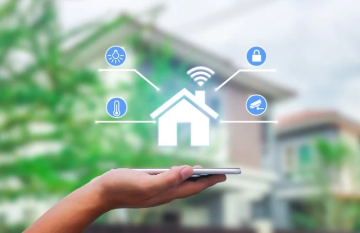 Una mano che tiene un telefono per controllare la casa 
