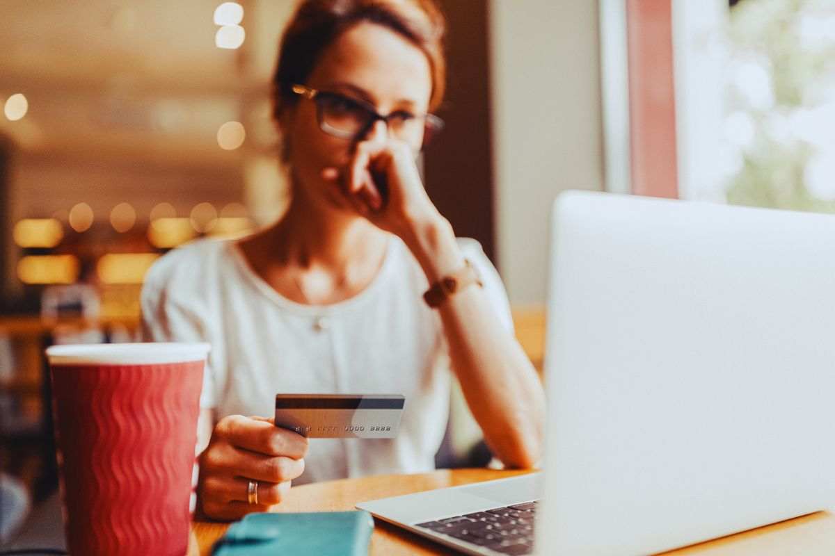 Donna preoccupata con carta di credito in mano