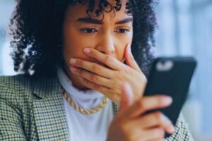 Donna preoccupata mentre legge qualcosa su smartphone