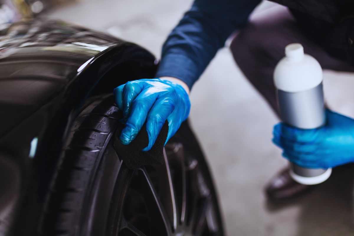 Persona che lucida il cerchio dell'auto