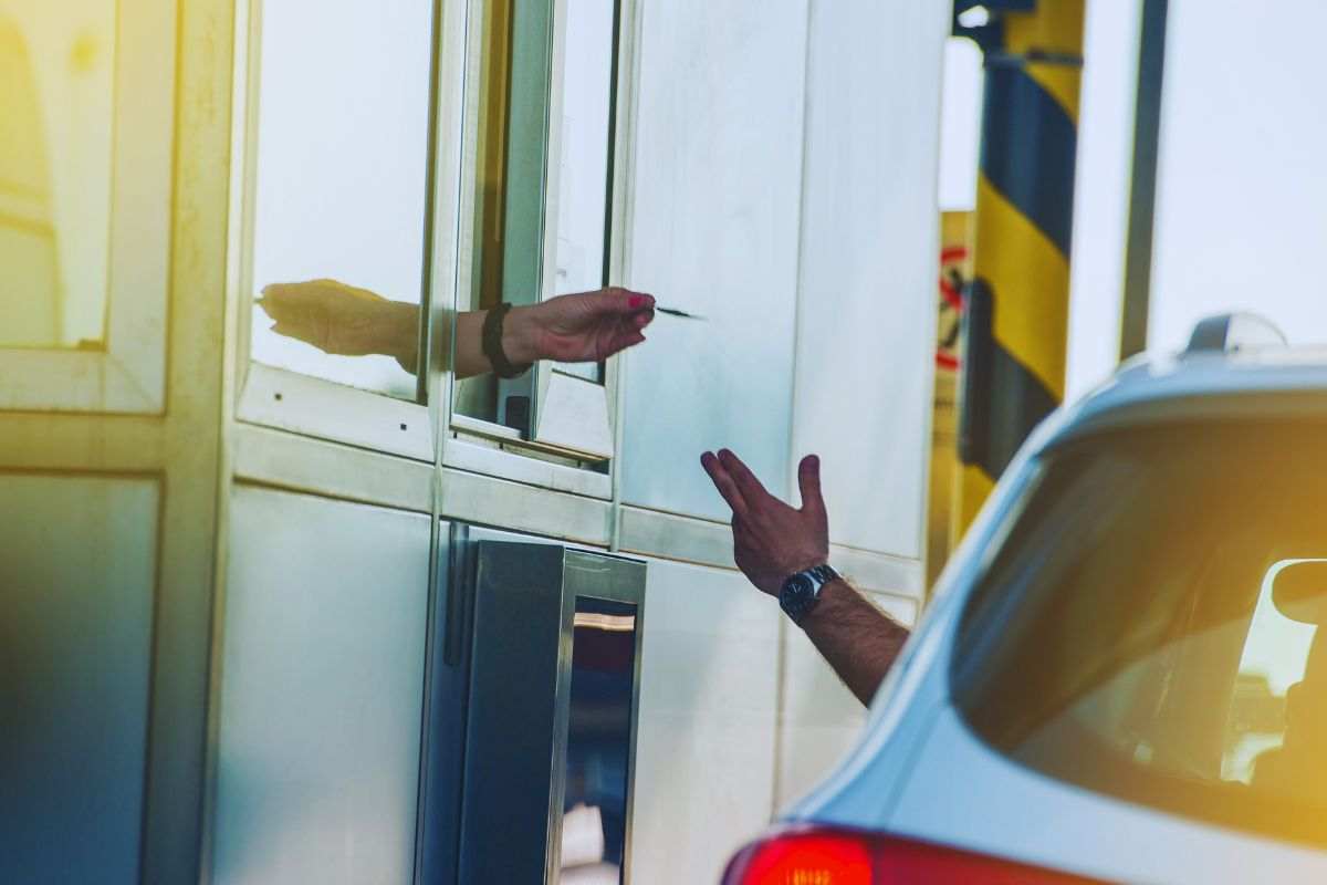 Automobilista che paga al casello