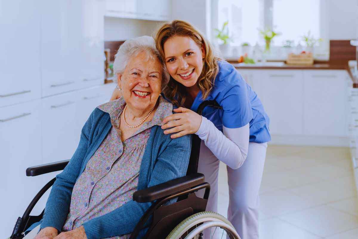 Donna sorridente che abbraccia anziana disabile