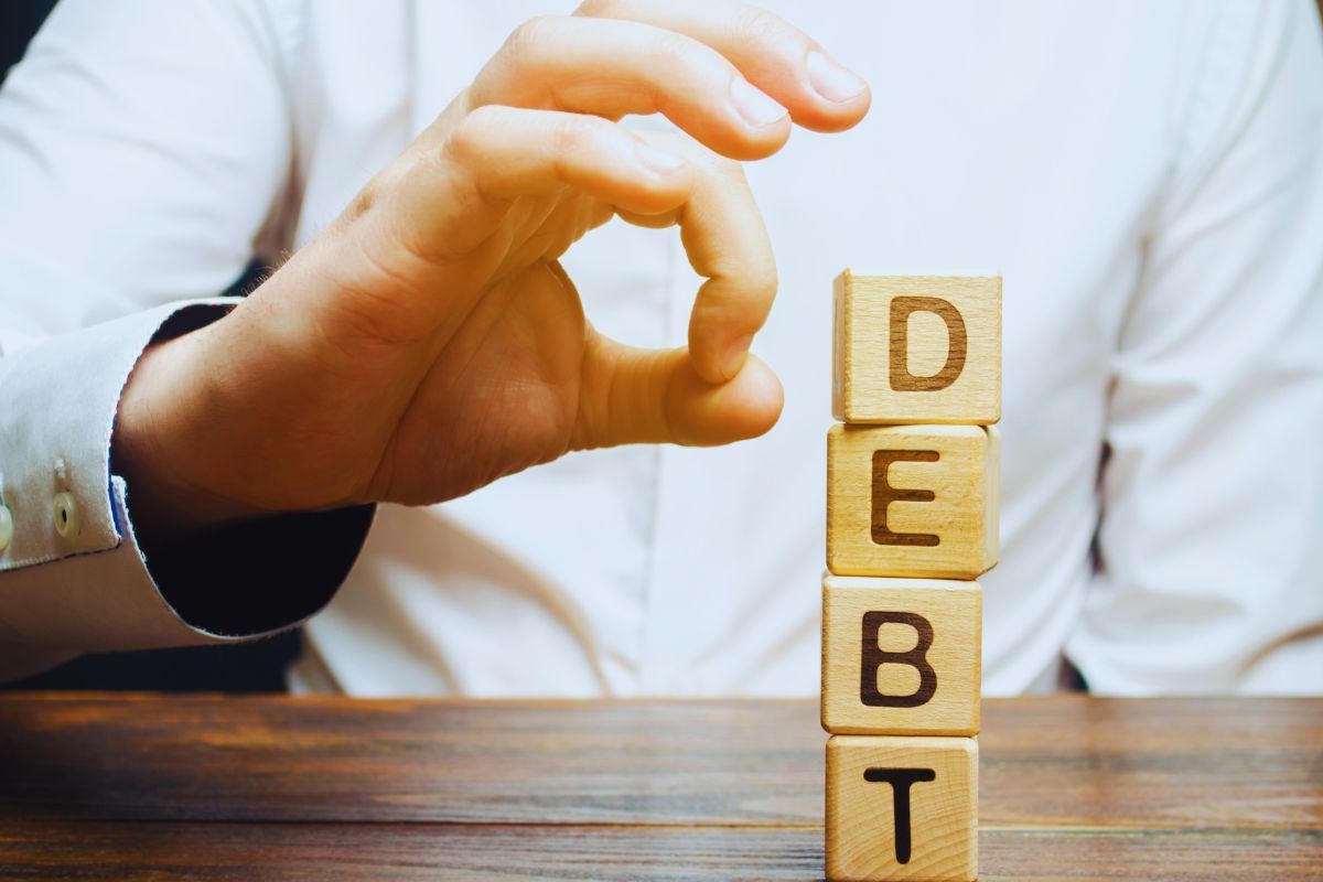 Persona che si prepara a cancellare la scritta "Debiti"