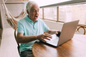 Pensionato con espressione sorpresa al pc