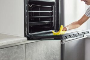Persona intenta nella pulizia del forno