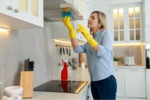 donna pulisce con una spugna la cappa della cucina