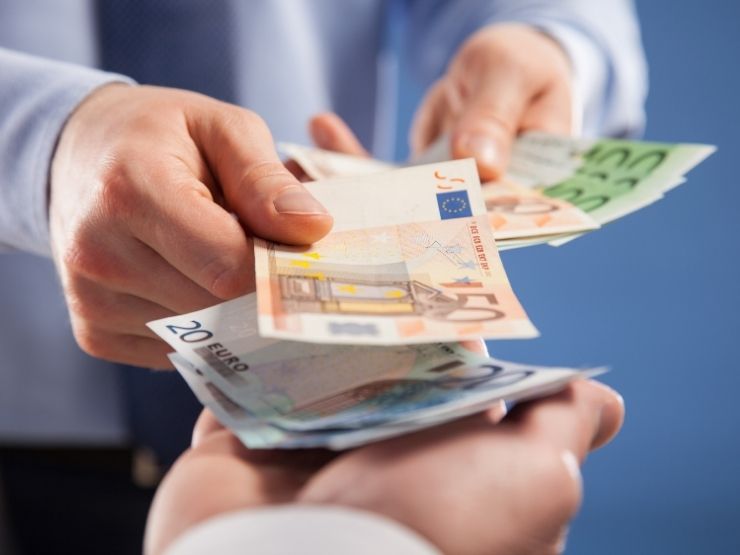 uomo che paga con banconote un altra persona
