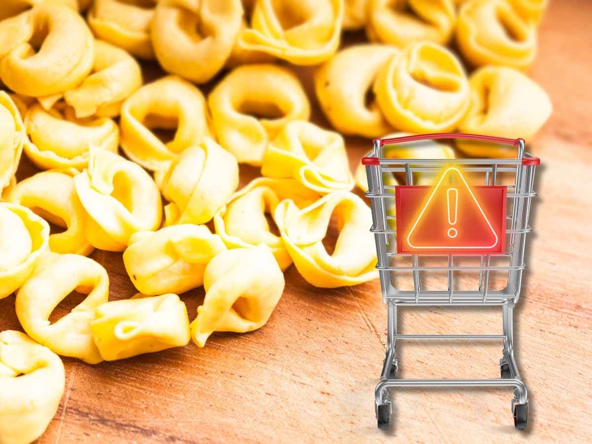 tortellini freschi sullo sfondo, carrello spesa con simbolo pericolo in primo piano