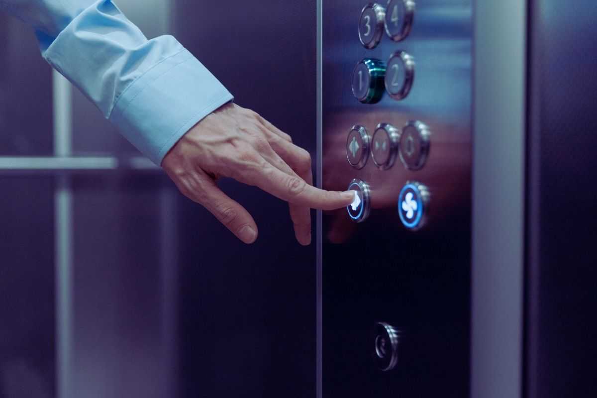 mano preme tasto dell'ascensore