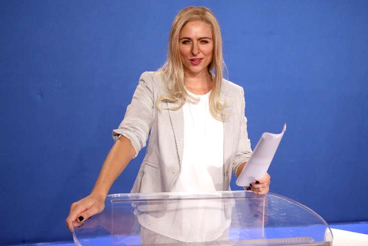 brenda lodigiani davanti a un tavolo di vetro con dei fogli in mano