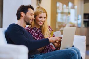 ragazzi pagano al computer con una carta e sorridono