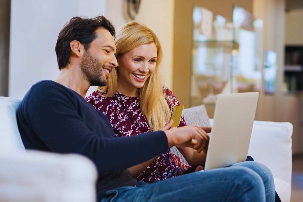 ragazzi pagano al computer con una carta e sorridono