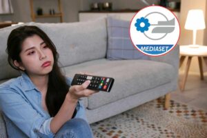 donna scocciata che guarda tv e logo mediaset