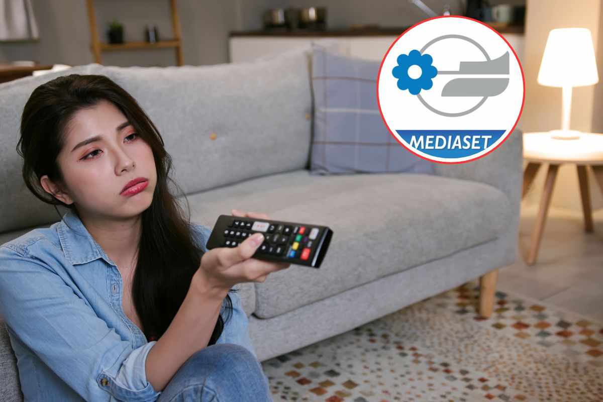 donna scocciata che guarda tv e logo mediaset