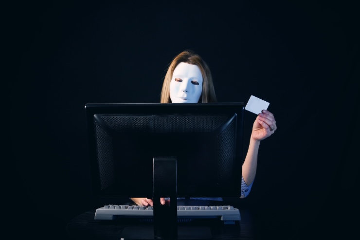 donna al pc con maschera e carta