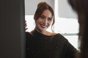una donna sorride alla porta