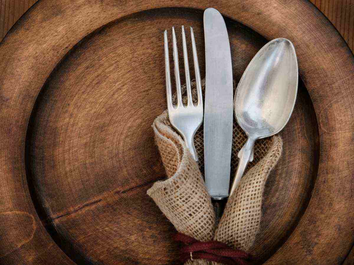 piatto di legno e posate in tovagliolo di yuta