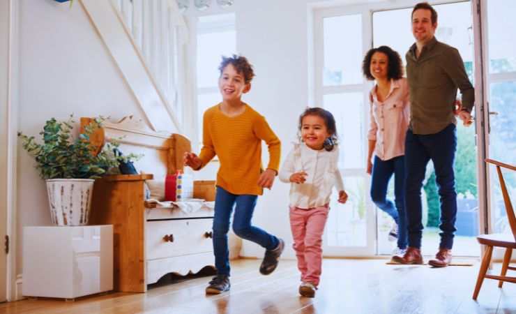 bambini che entrano in casa correndo e genitori