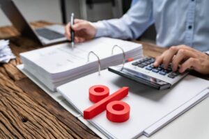 mani che scrivono con penna, calcolatrice, percentuale
