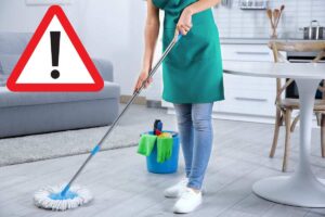 donna pulisce il pavimento con il segnale di pericolo
