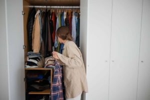 Donna prende camicia da armadio