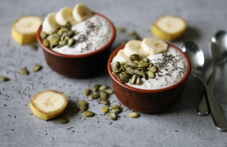 Ciotole con yogurt, semi di zucca e banana